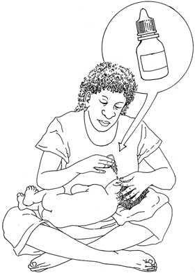 The child lies on the carer's lap while they put eardrops into his ear after doing tissue spears.